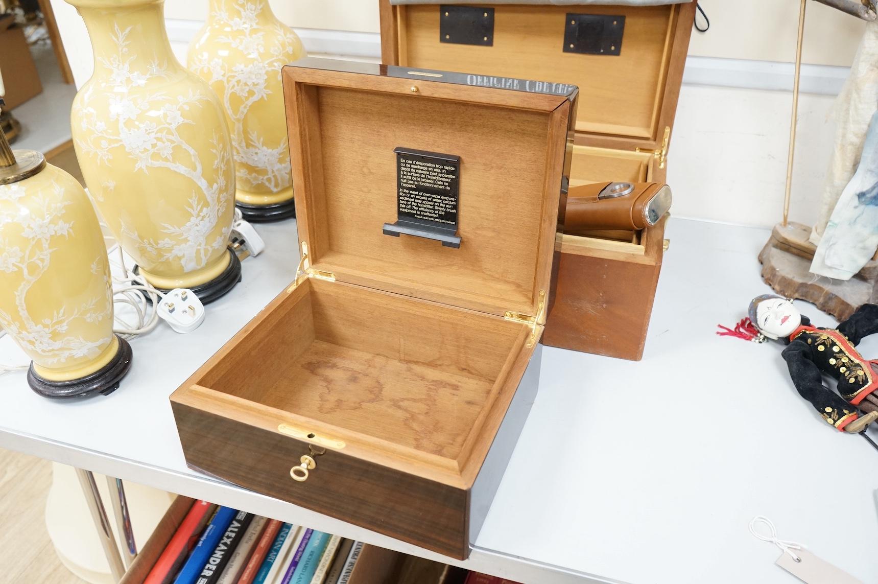 Two wooden humidors, one inlaid, together with a leather cigar case, largest 42cm x 30cm.